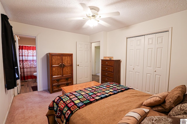 bedroom with ensuite bathroom, ceiling fan, light carpet, a textured ceiling, and a closet