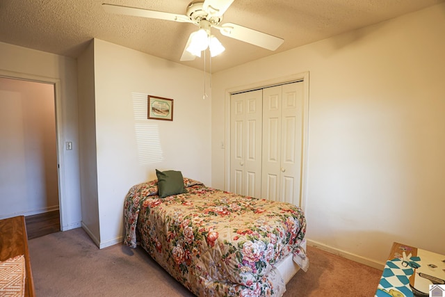 bedroom featuring ceiling fan, carpet floors, a closet, and a textured ceiling