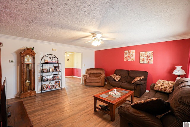 living room with hardwood / wood-style flooring, ceiling fan, crown molding, and a textured ceiling