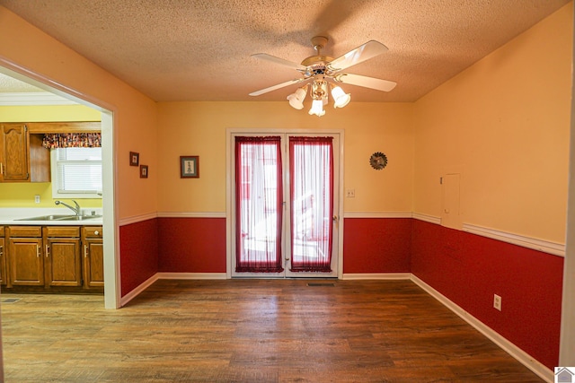 interior space featuring sink, ceiling fan, wood-type flooring, a textured ceiling, and a baseboard radiator