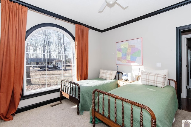 carpeted bedroom featuring ornamental molding and ceiling fan