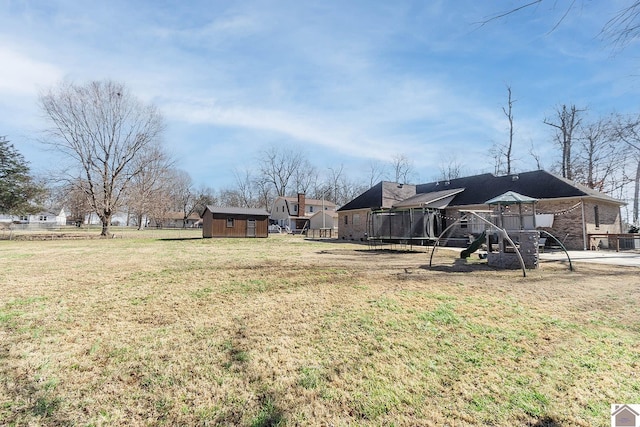 view of yard with a storage unit, a playground, and a trampoline