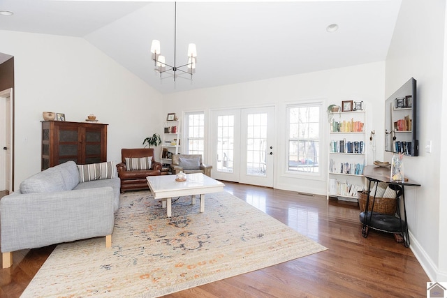 living room featuring dark wood-type flooring, lofted ceiling, and a chandelier