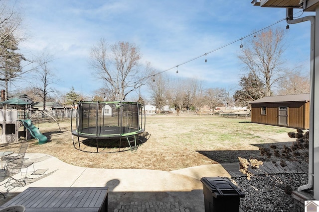 view of yard with a playground, a trampoline, and a shed