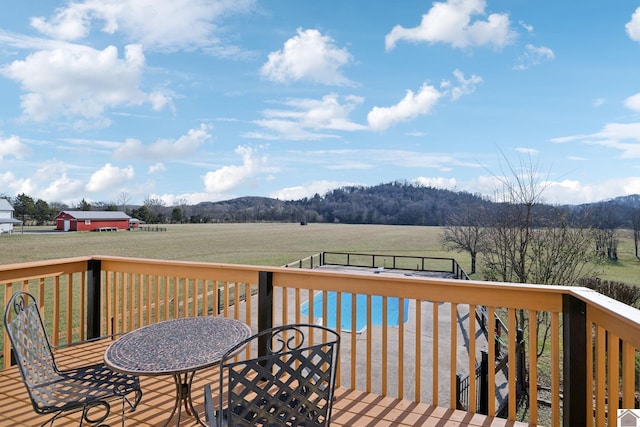 deck featuring a lawn and a rural view