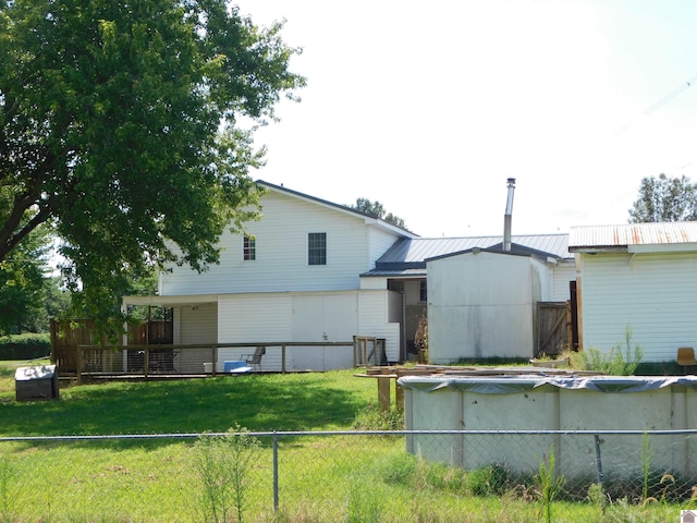 back of property with a lawn and a covered pool