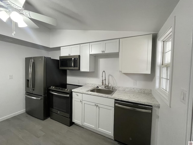 kitchen featuring white cabinetry, lofted ceiling, stainless steel appliances, and sink