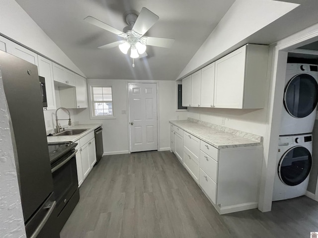 kitchen with stacked washer and dryer, black appliances, sink, and white cabinets