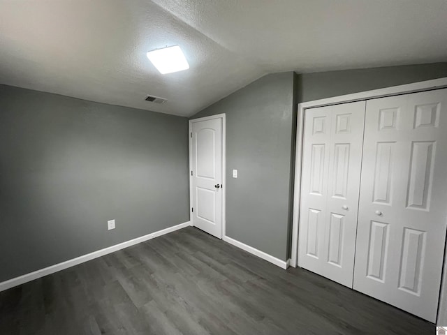 bonus room with lofted ceiling, dark hardwood / wood-style floors, and a textured ceiling