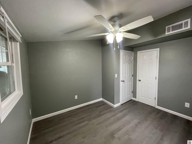 unfurnished room featuring dark hardwood / wood-style flooring, a textured ceiling, and ceiling fan