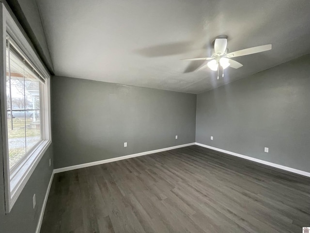 spare room featuring dark wood-type flooring and ceiling fan