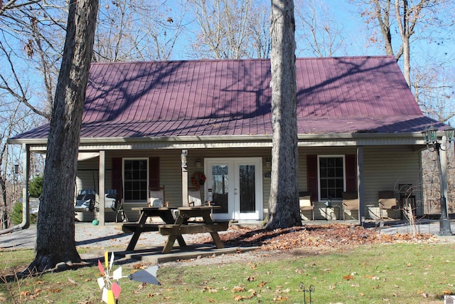 exterior space with a front lawn, a patio area, and french doors