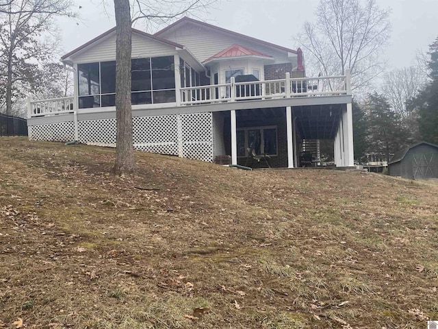 back of property with a sunroom and a deck