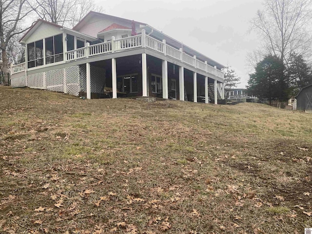 rear view of house with a sunroom and a yard