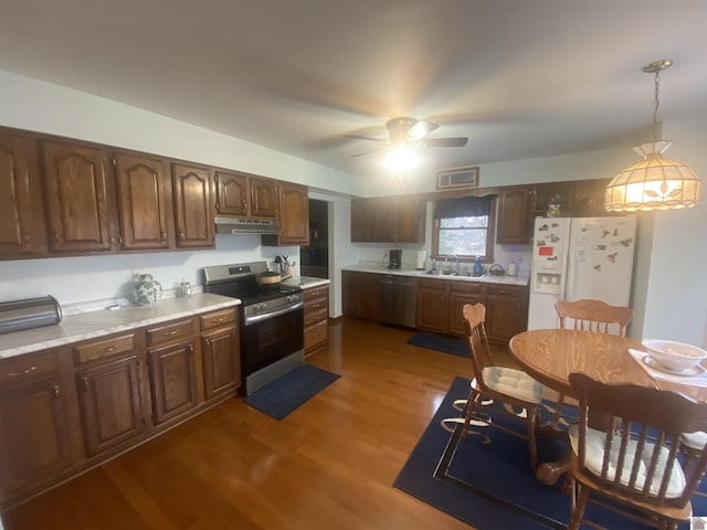 kitchen featuring dark wood-type flooring, sink, decorative light fixtures, ceiling fan, and stainless steel appliances