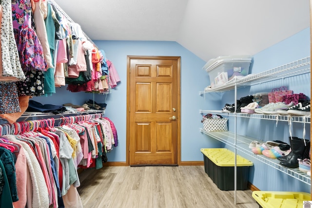 walk in closet with lofted ceiling and light hardwood / wood-style floors