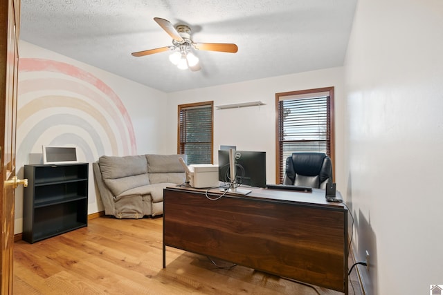 office area with ceiling fan, a textured ceiling, and light wood-type flooring