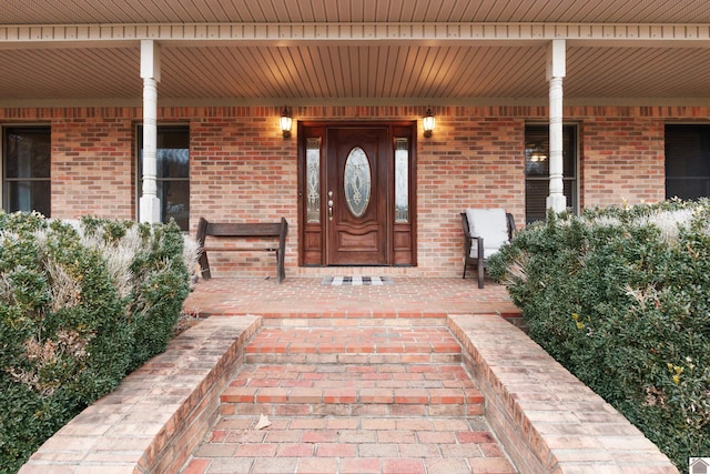 view of exterior entry featuring covered porch