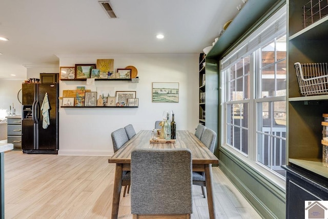 dining space with crown molding and hardwood / wood-style floors