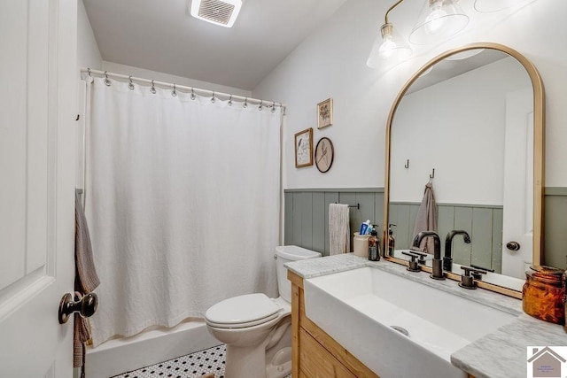 full bathroom featuring vanity, shower / tub combo, and toilet