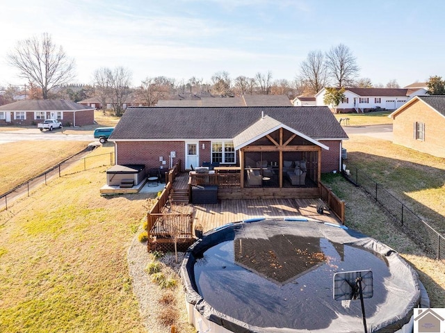 back of property featuring a pool side deck, a lawn, and a sunroom