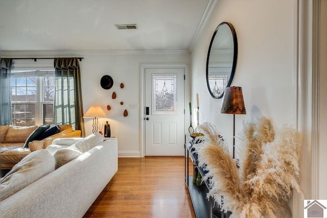 foyer entrance featuring crown molding and light hardwood / wood-style flooring