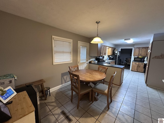 dining room featuring light tile patterned flooring and a textured ceiling