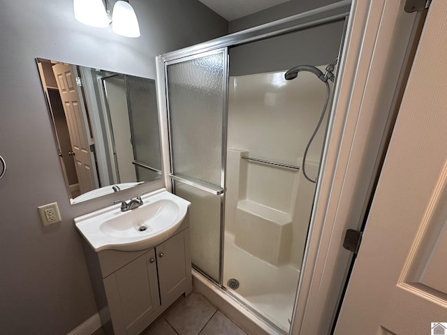 bathroom featuring walk in shower, vanity, and tile patterned flooring