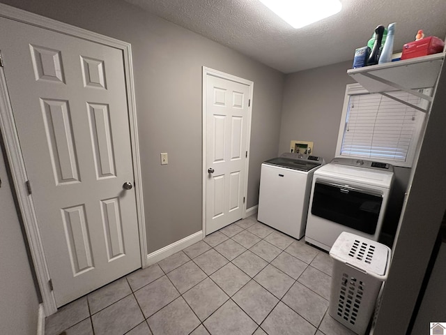 laundry room featuring light tile patterned flooring, independent washer and dryer, and a textured ceiling