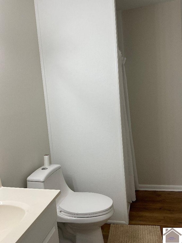 bathroom featuring vanity, hardwood / wood-style flooring, and toilet