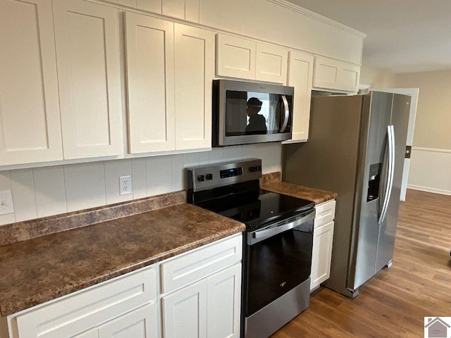 kitchen featuring white cabinetry, appliances with stainless steel finishes, and dark hardwood / wood-style flooring