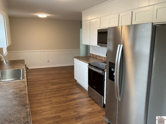 kitchen featuring dark wood-type flooring, sink, white cabinetry, ornamental molding, and appliances with stainless steel finishes