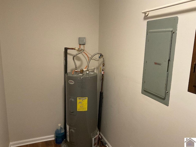 utility room featuring electric panel and water heater