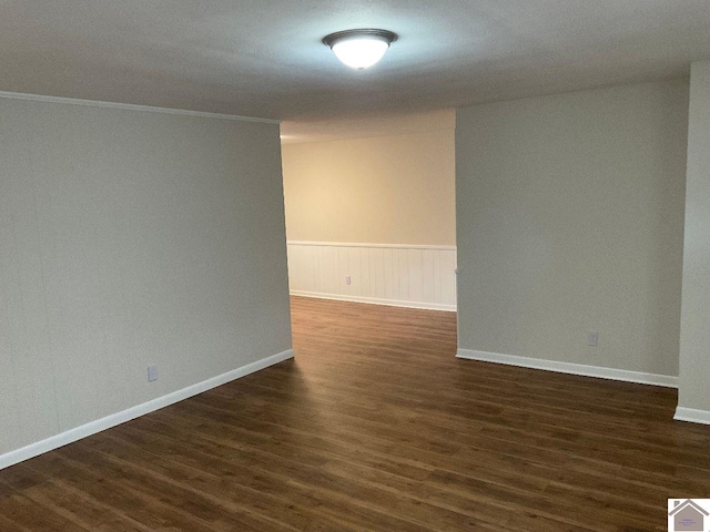 spare room with dark hardwood / wood-style flooring and ornamental molding