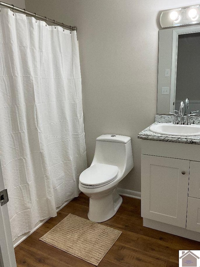 bathroom with hardwood / wood-style flooring, vanity, and toilet