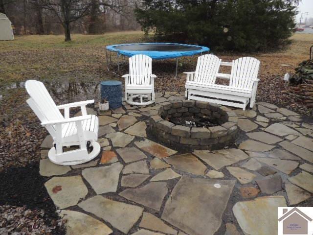 view of patio with a trampoline and an outdoor fire pit