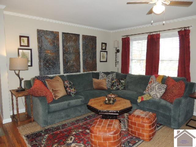 living room with hardwood / wood-style floors, crown molding, and ceiling fan