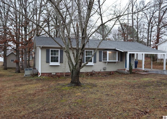 view of front of house featuring central AC unit, a front yard, and a carport