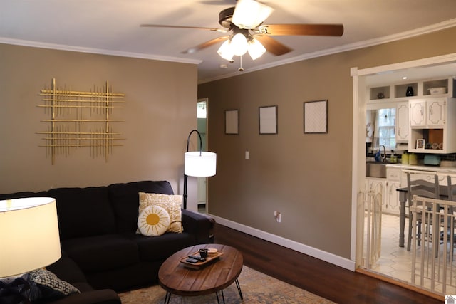 living room with ceiling fan, ornamental molding, dark hardwood / wood-style flooring, and sink