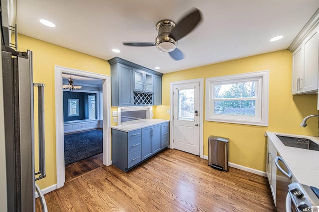 kitchen featuring white cabinetry, sink, wood-type flooring, and blue cabinets