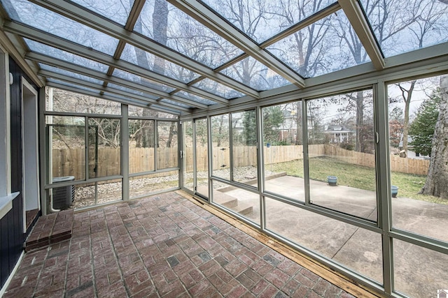 unfurnished sunroom featuring vaulted ceiling and a wealth of natural light