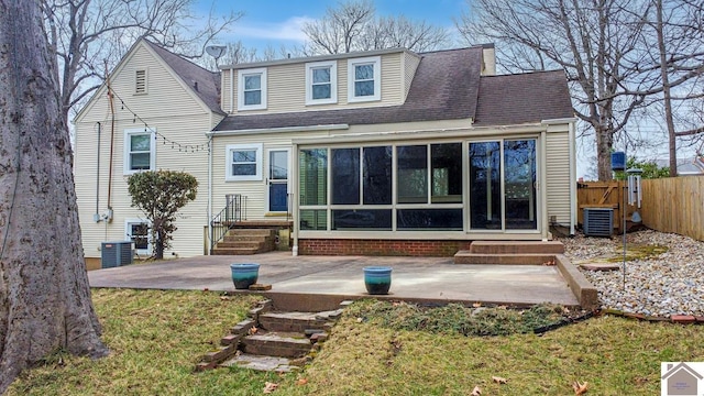 rear view of house featuring central AC unit, a lawn, a sunroom, and a patio