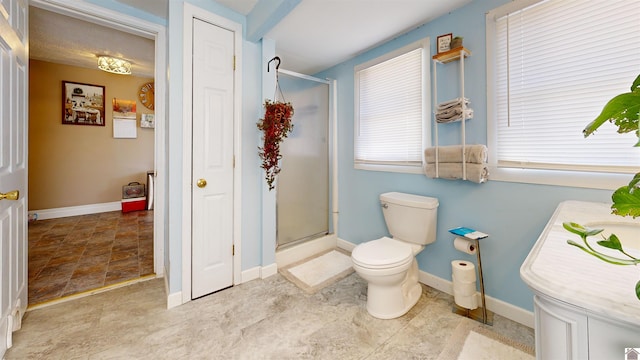 bathroom featuring vanity, toilet, and a shower with door