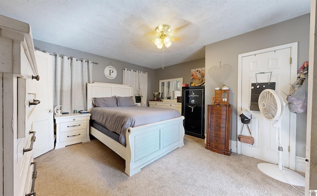 carpeted bedroom featuring ceiling fan and a textured ceiling