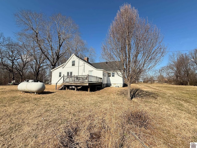 view of home's exterior featuring a wooden deck and a lawn