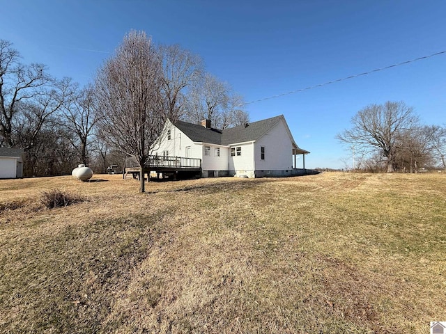 rear view of house with a yard and a deck