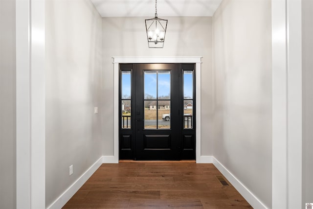 foyer with dark hardwood / wood-style floors and a notable chandelier