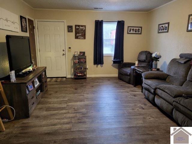 living room with baseboards, a textured ceiling, ornamental molding, and dark wood-style flooring