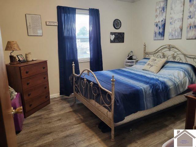 bedroom with baseboards and wood finished floors