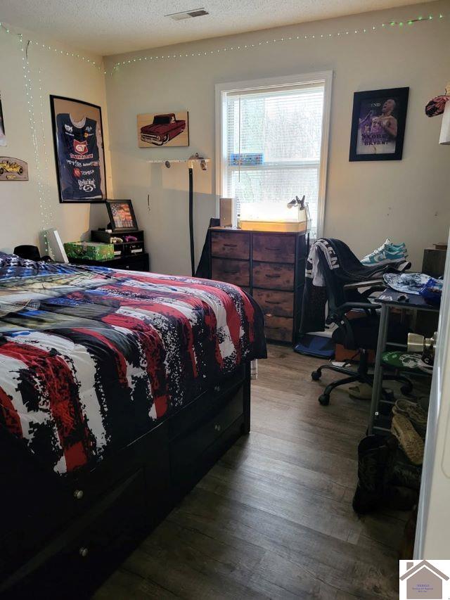 bedroom with visible vents and wood finished floors